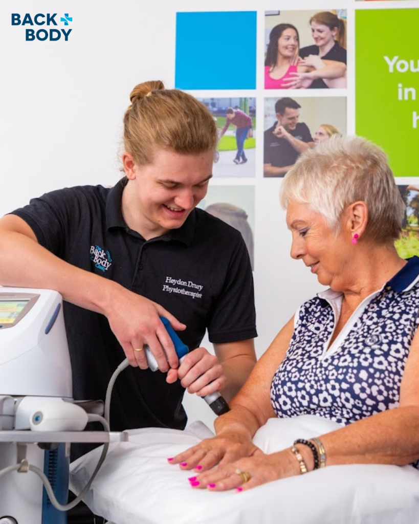 Physiotherapist using a shockwave machine on a ladies forearm